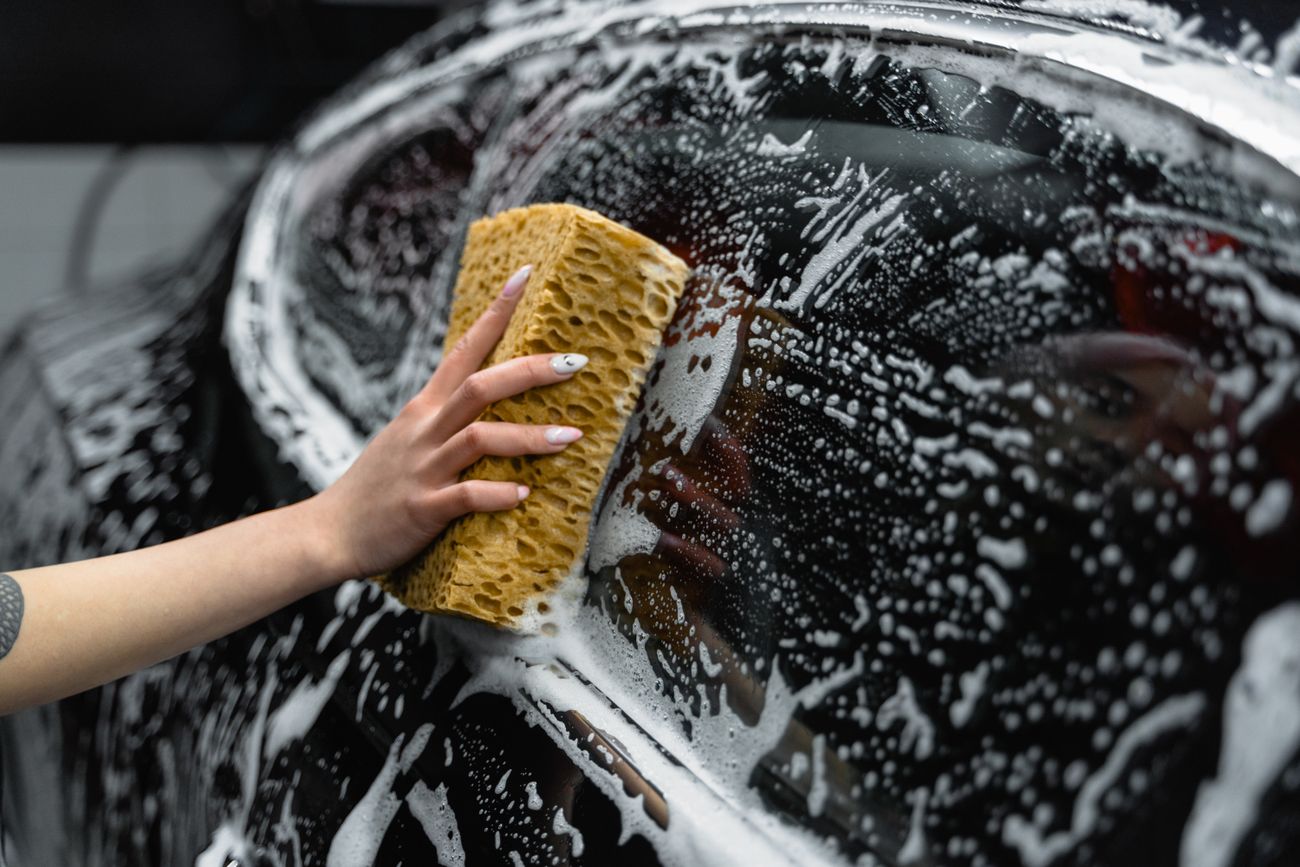 A close-up of car glass covered in foam during a careful wash